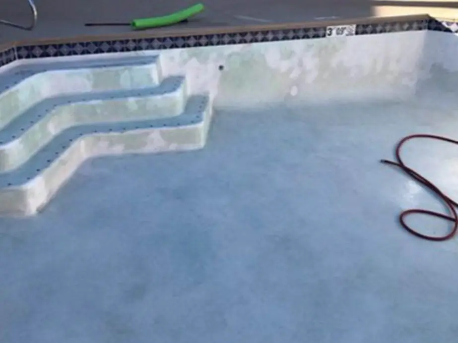 Drained plaster pool and entry steps washed back to an even pale finish