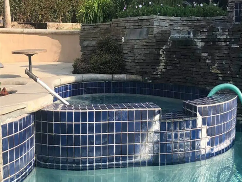 Raised spa wall of cobalt tile streaked with white hard-water scale